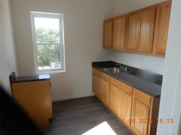 a kitchen with sink a window and cabinets