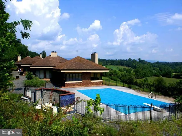 a view of a house with pool and chairs