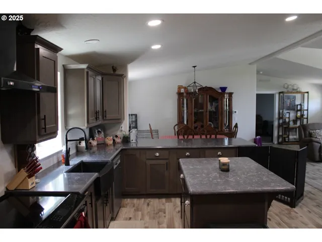 a kitchen with stainless steel appliances kitchen island granite countertop a sink and cabinets