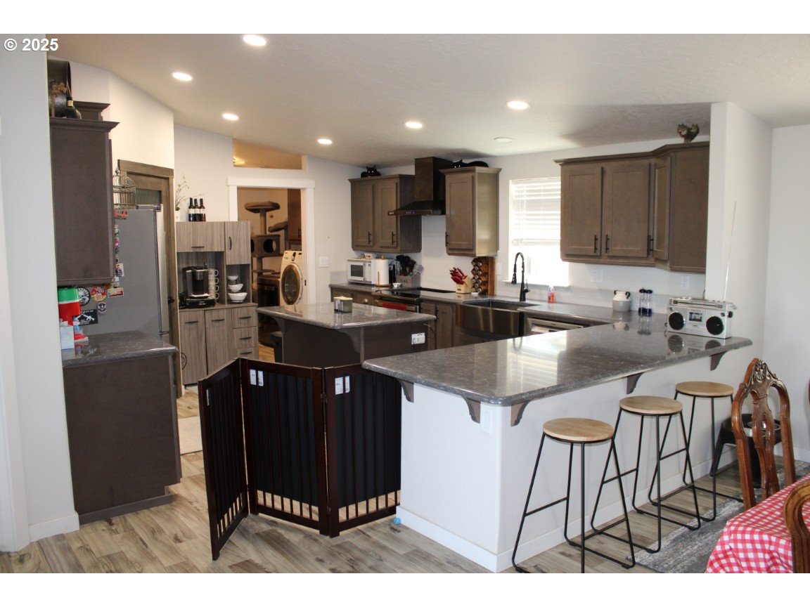 526 Southeast 15th Street Pendleton, OR 97801 - Photo 8 of 31 a kitchen with stainless steel appliances kitchen island granite countertop a sink and cabinets