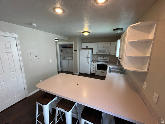432 Spring Lane Logan, UT 84341 - Photo 10 of 22 Kitchen with light countertops, white appliances, open shelves, a peninsula, and a textured ceiling