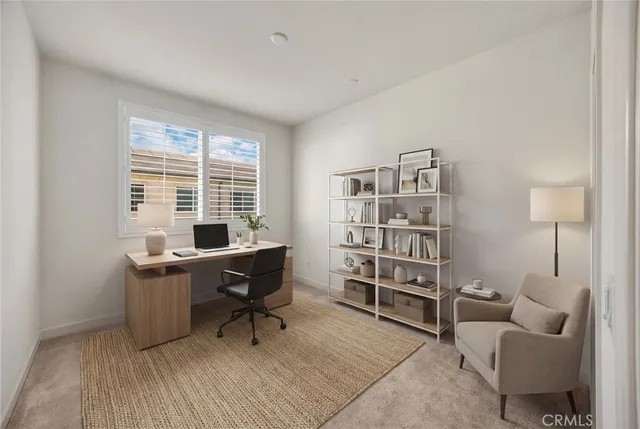 a view of a workspace with furniture and a window