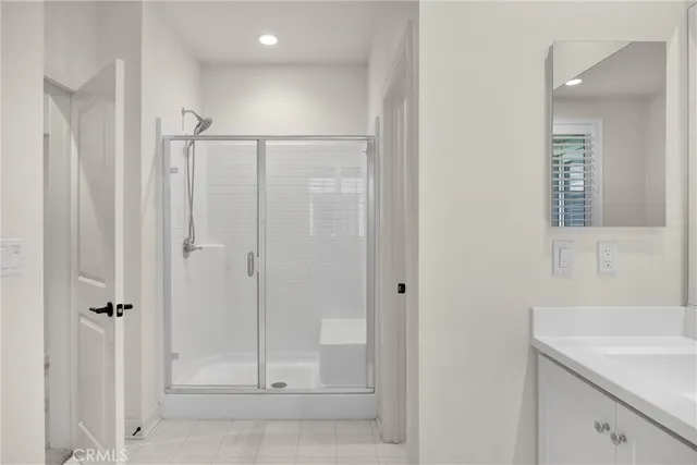 a bathroom with a shower sink and vanity