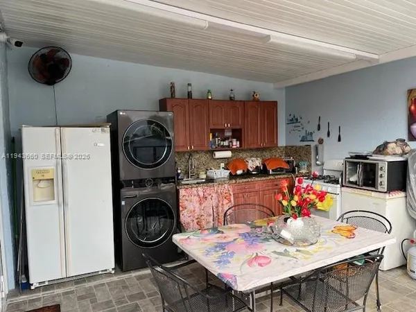 a kitchen with a stove a refrigerator and a dining table