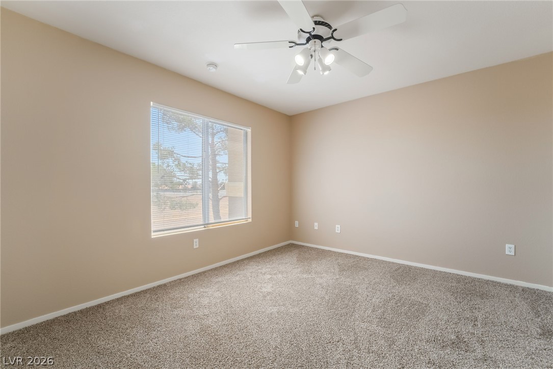 8070 West Russell Road, Unit 2024 Las Vegas, NV 89113 - Photo 10 of 19 A well-lit bedroom features plush carpeting and a ceiling fan for comfort.
