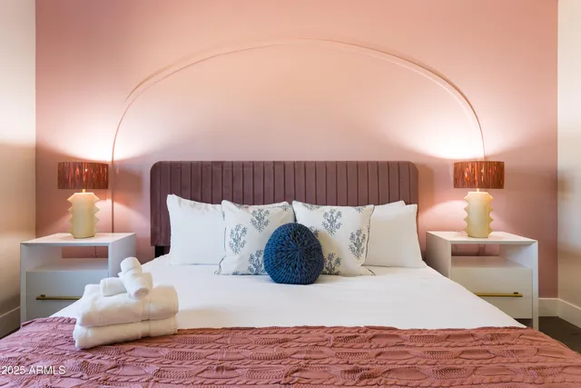 a large bed sitting in a bedroom next to a lamp