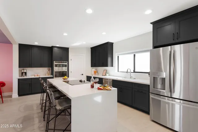 a kitchen with stainless steel appliances a stove a sink a refrigerator and a refrigerator