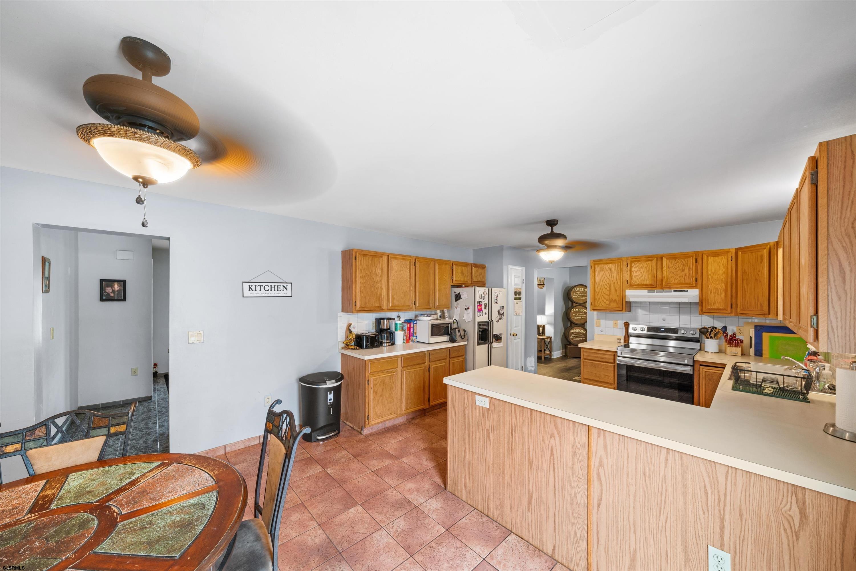 1319 Somers Point Road Egg Harbor Township, NJ 08234 - Photo 38 of 83 a kitchen with a stove a refrigerator a sink dishwasher a dining table and chairs with wooden floor
