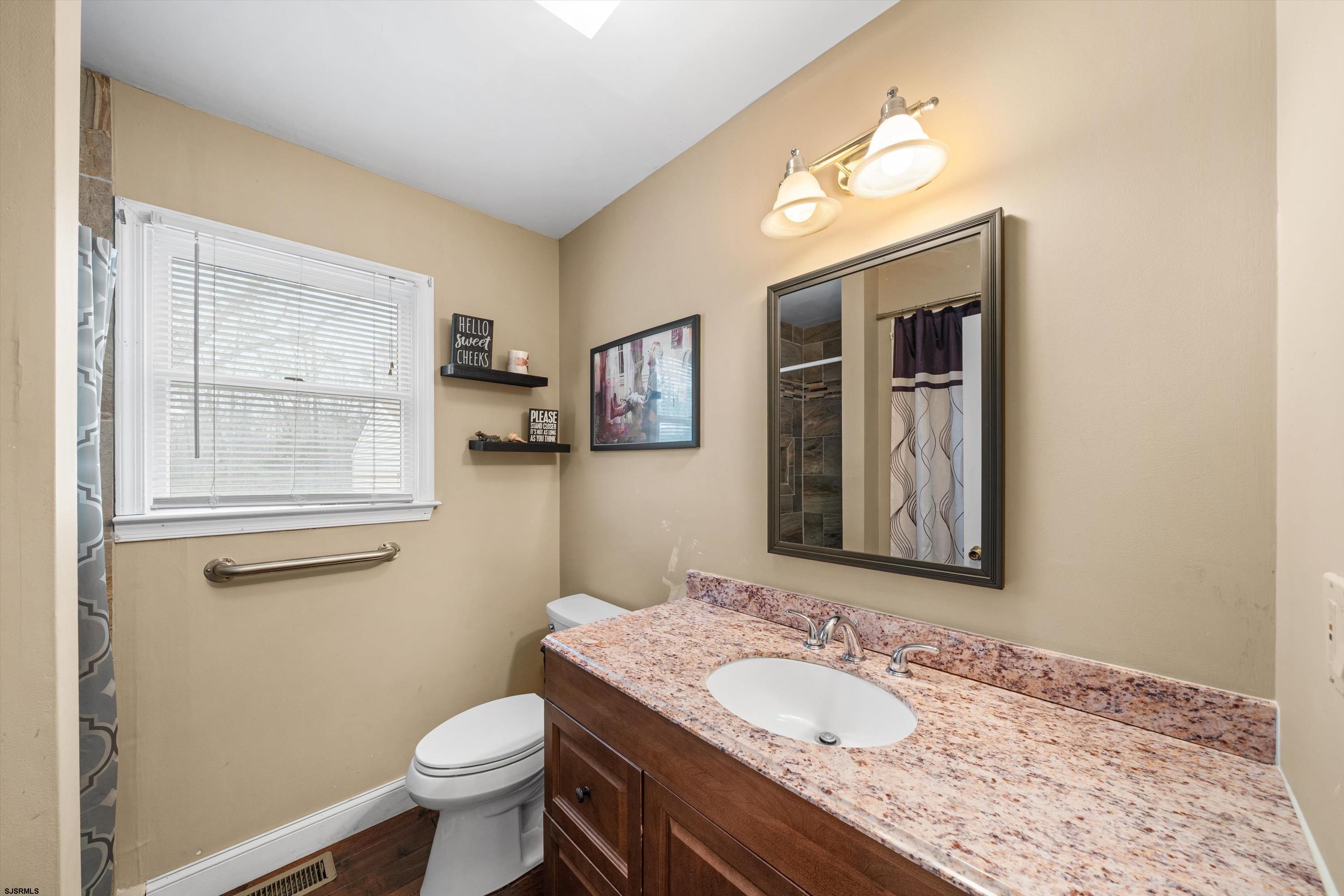 1319 Somers Point Road Egg Harbor Township, NJ 08234 - Photo 42 of 83 a bathroom with a granite countertop toilet sink and mirror