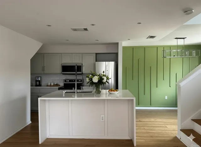 a kitchen with kitchen island granite countertop a sink and cabinets