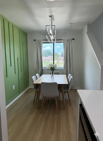 a dining room with furniture a chandelier and wooden floor