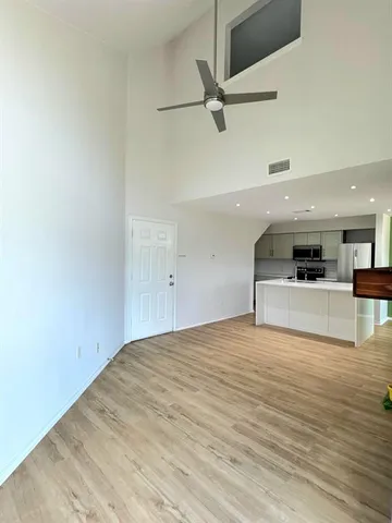 a view of a livingroom with a kitchen counter tops and a wooden floor