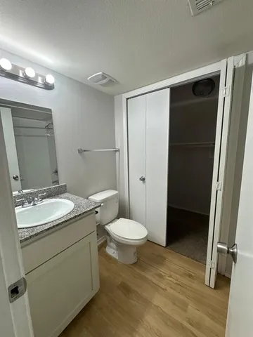 a bathroom with a granite countertop sink toilet and shower
