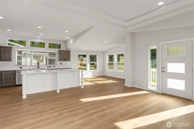a view of a kitchen with kitchen island a sink stainless steel appliances and cabinets