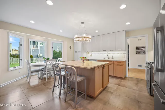 a kitchen with kitchen island a appliances dining table and chairs