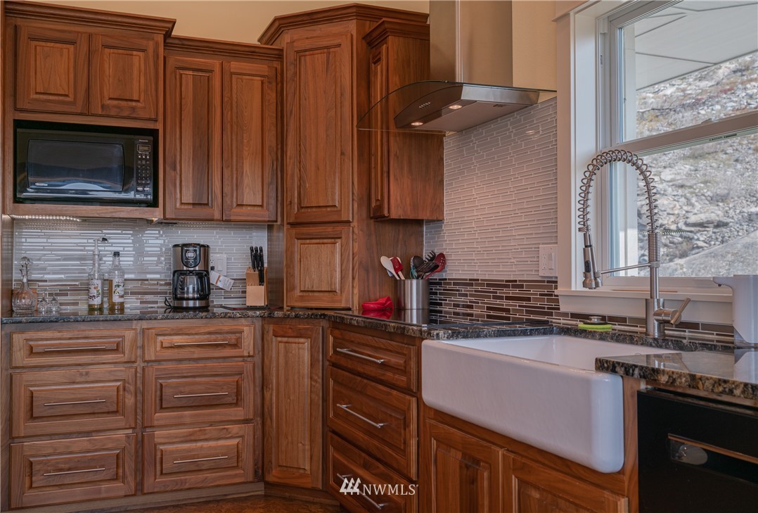 70 B Tunk Creek Road Riverside, WA 98849 - Photo 15 of 40 a kitchen with granite countertop wooden cabinets and a stove top oven