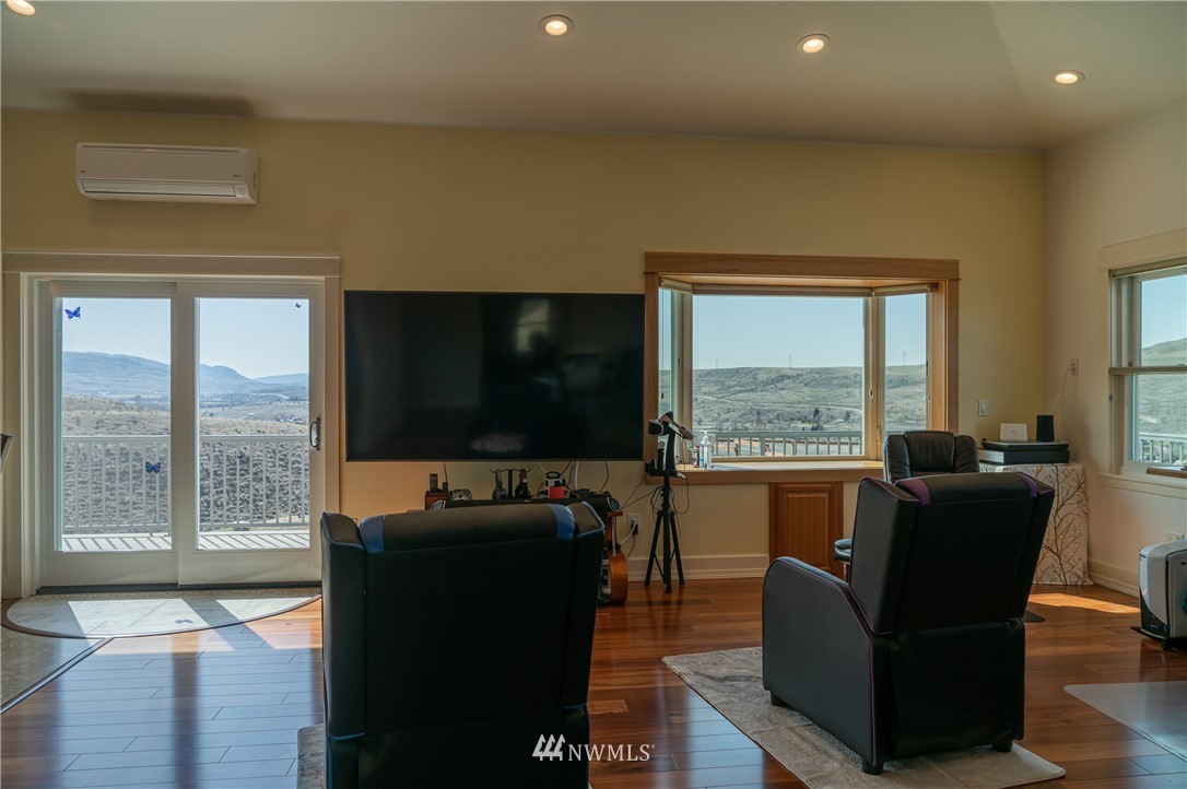 70 B Tunk Creek Road Riverside, WA 98849 - Photo 10 of 40 a living room with furniture a flat screen tv and floor to ceiling window