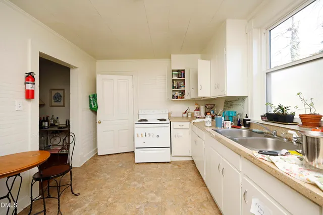 a large white kitchen with cabinets