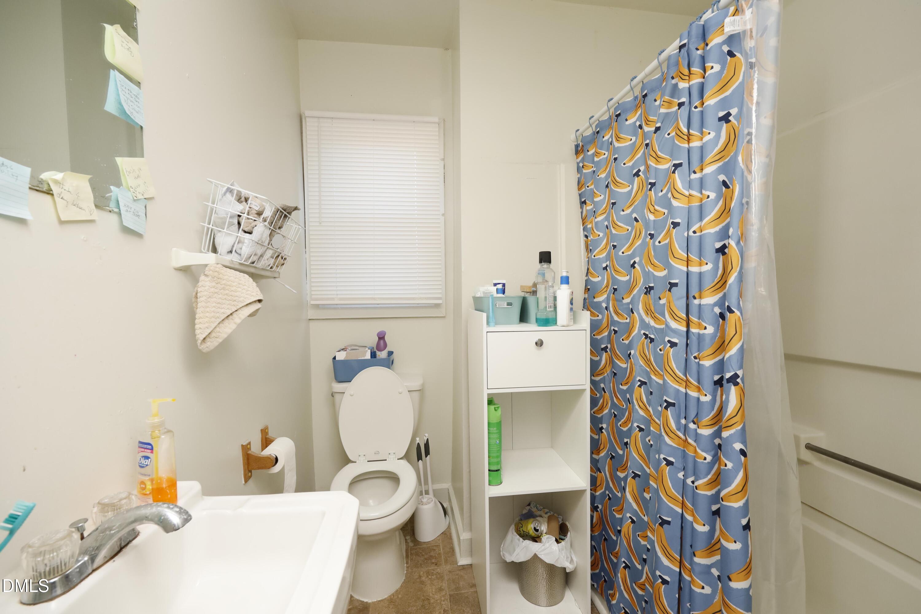 822 Clarendon Street Durham, NC 27705 - Photo 5 of 8 a bathroom with a sink toilet and shower curtain