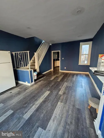 a view of a livingroom with wooden floor and stairs