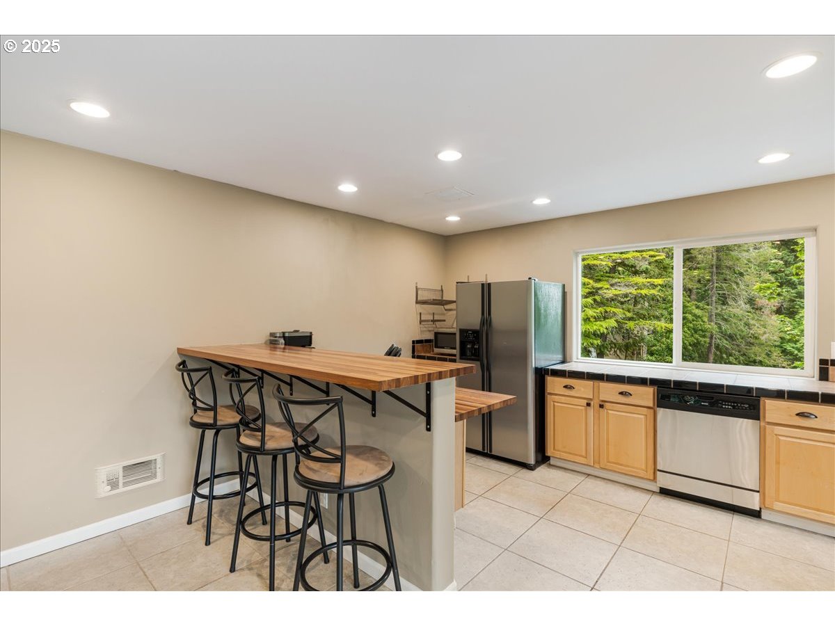 30062 Maple Drive Rainier, OR 97048 - Photo 9 of 47 a kitchen with stainless steel appliances kitchen island granite countertop a table and chairs in it