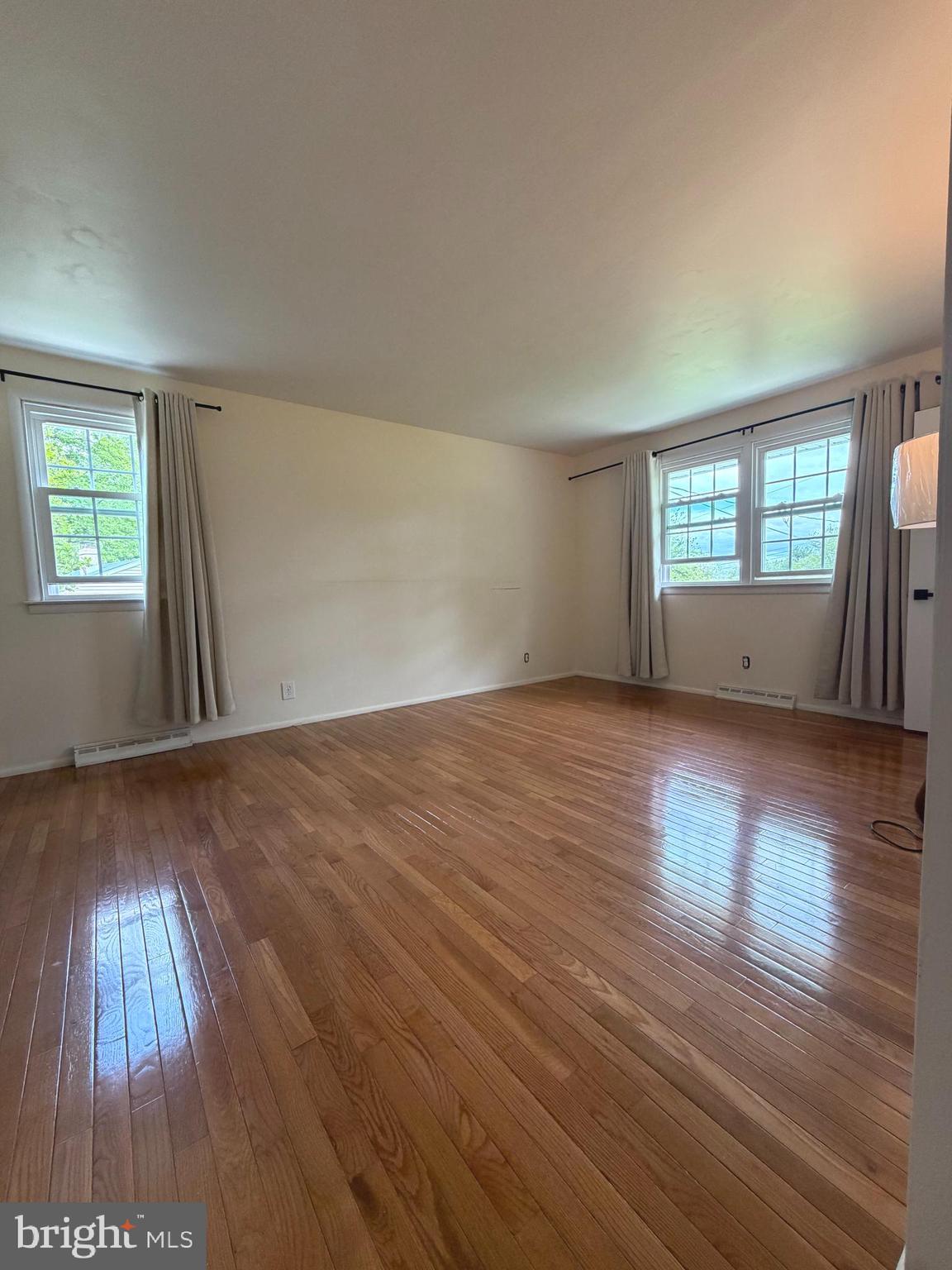 1207 Greenhill Road Flourtown, PA 19031 - Photo 4 of 9 an empty room with wooden floor and windows