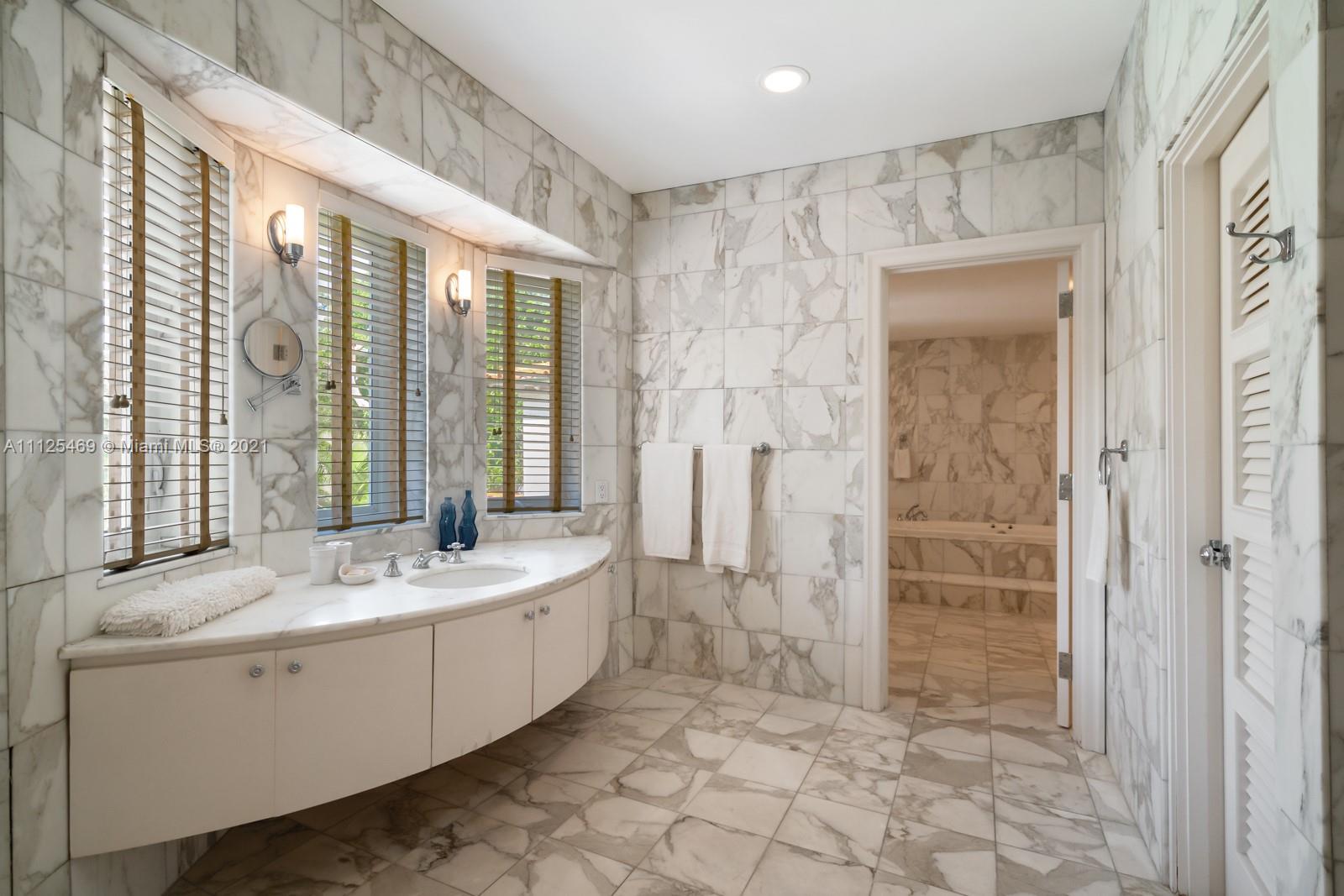 3029 Brickell Avenue Miami, FL 33133 - Photo 37 of 41 a spacious bathroom with a double vanity sink a large mirror and a bathtub