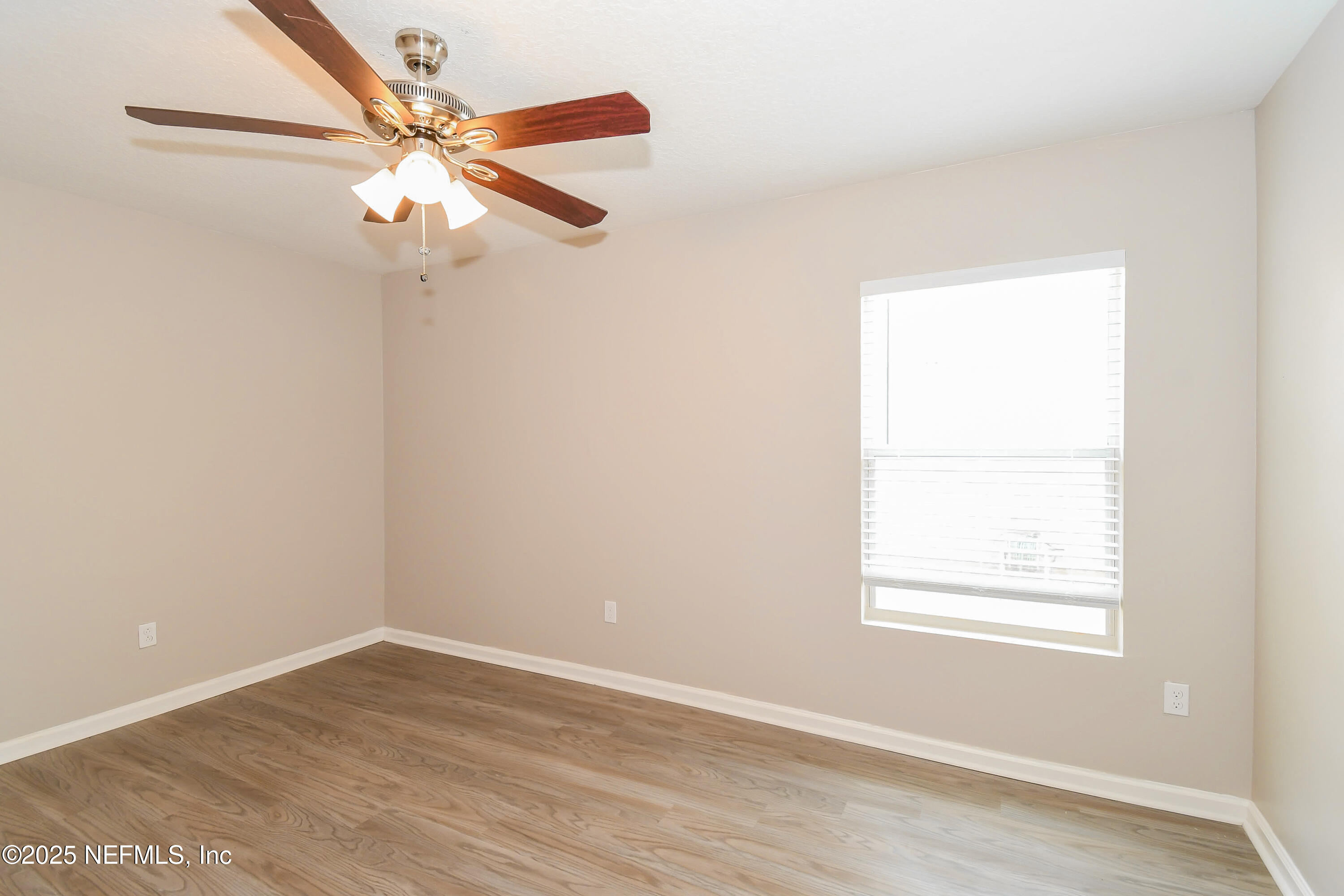 3786 Robena Road Jacksonville, FL 32218 - Photo 12 of 16 an empty room with wooden floor fan and windows