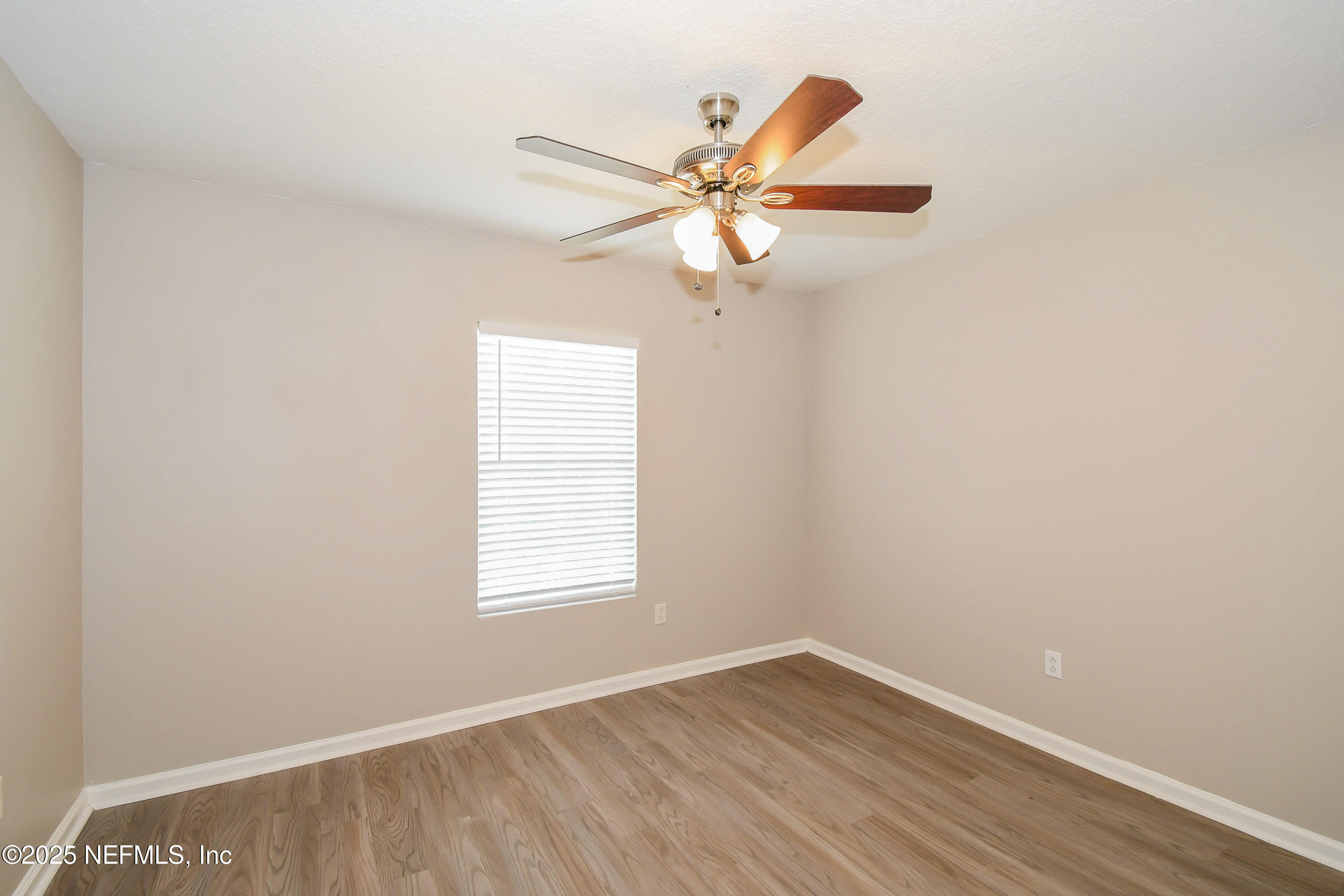 3786 Robena Road Jacksonville, FL 32218 - Photo 13 of 16 an empty room with wooden floor fan and windows