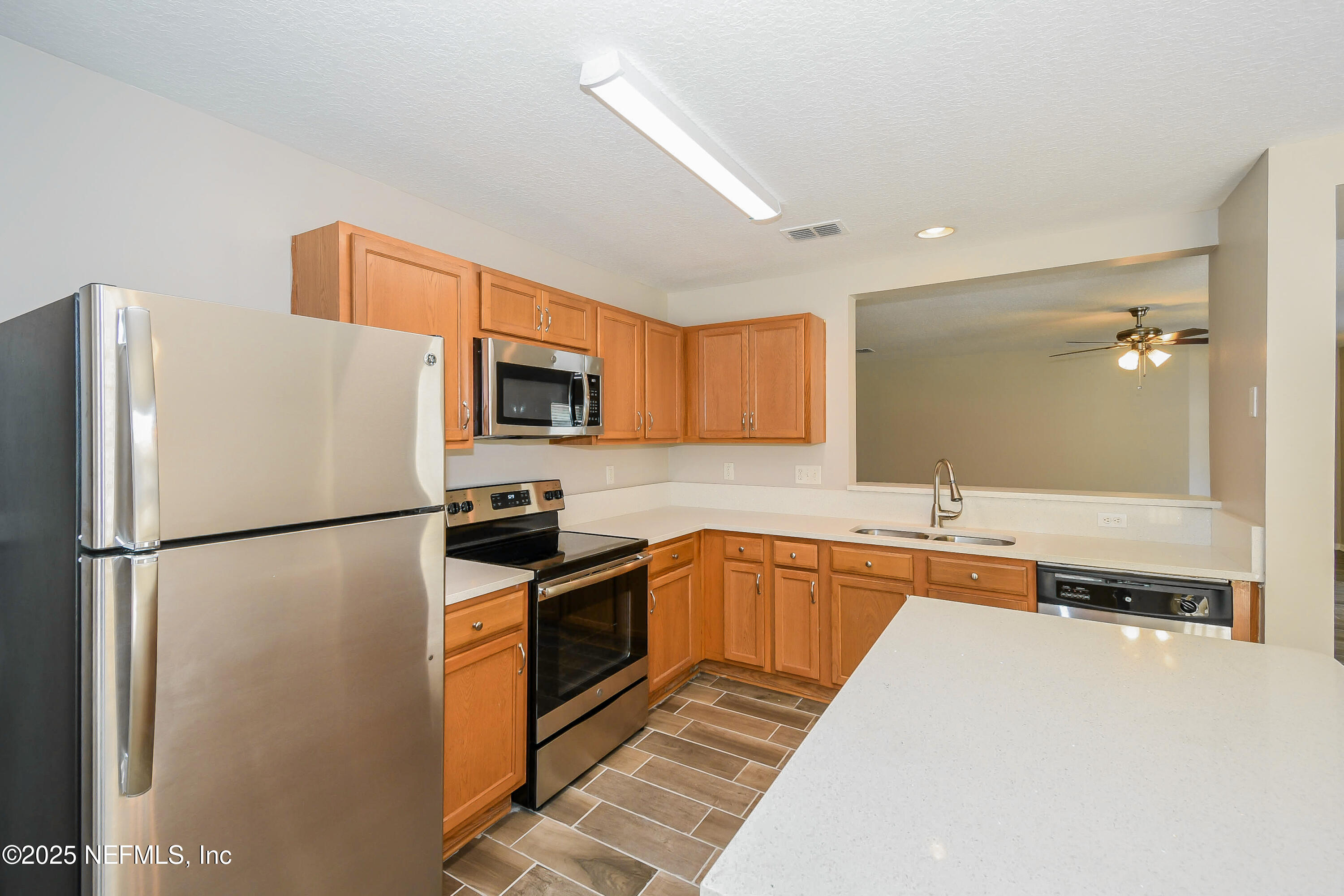3786 Robena Road Jacksonville, FL 32218 - Photo 6 of 16 a kitchen with stainless steel appliances granite countertop a refrigerator a stove a sink a microwave and island