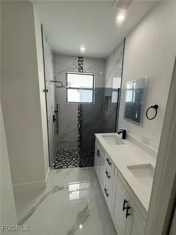 a bathroom with a double vanity sink a toilet a mirror and shower