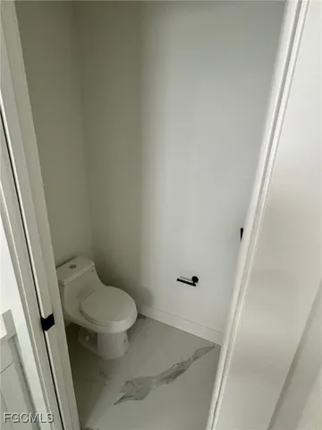 a white toilet sitting next to a white sink and vanity