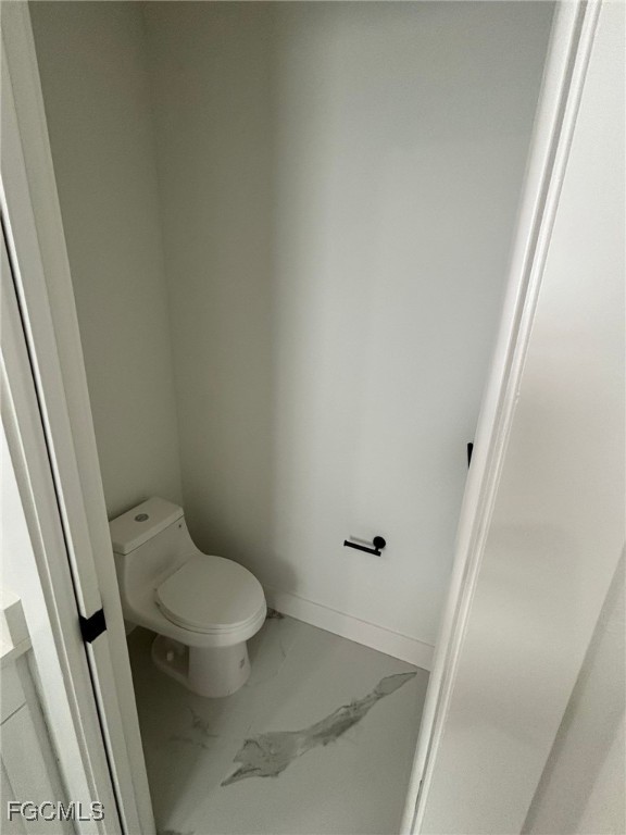 1233 Augusta Street East Lehigh Acres, FL 33974 - Photo 14 of 18 a white toilet sitting next to a white sink and vanity
