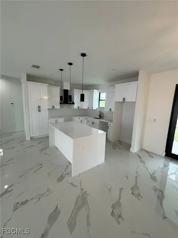 a large white kitchen with a stove a refrigerator a sink and dishwasher
