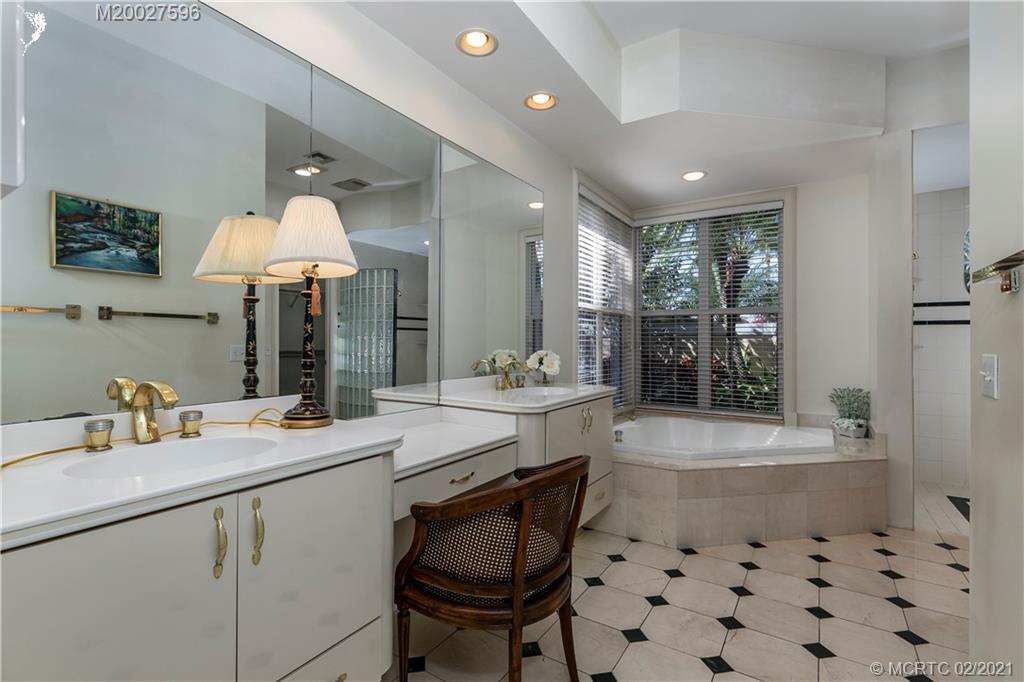 38 West High Point Road Stuart, FL 34996 - Photo 14 of 32 a bathroom with a sink a large mirror and a bathtub