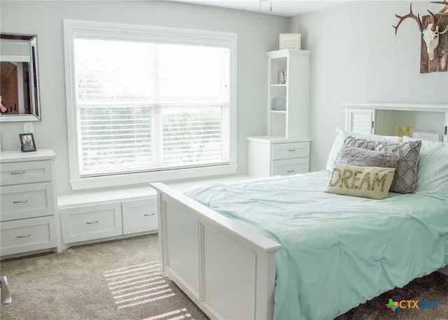 a bedroom with a large bed and a window