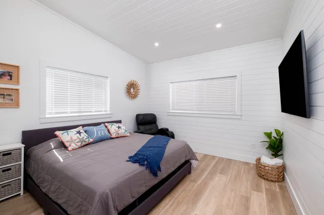 a bedroom with a bed and flat screen tv