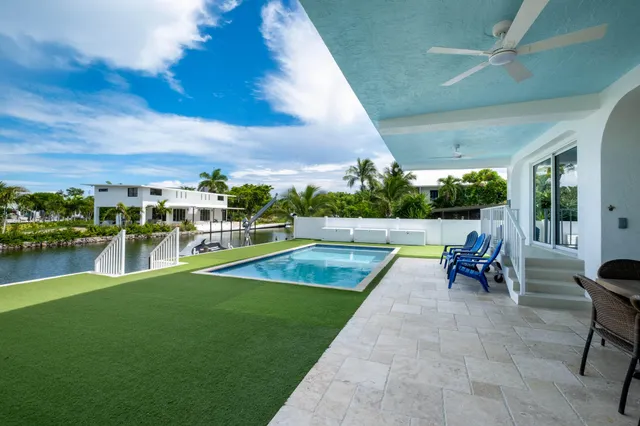 a view of a swimming pool with a table and chairs in patio