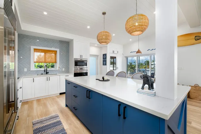 a kitchen with stainless steel appliances kitchen island granite countertop a sink a stove and cabinets