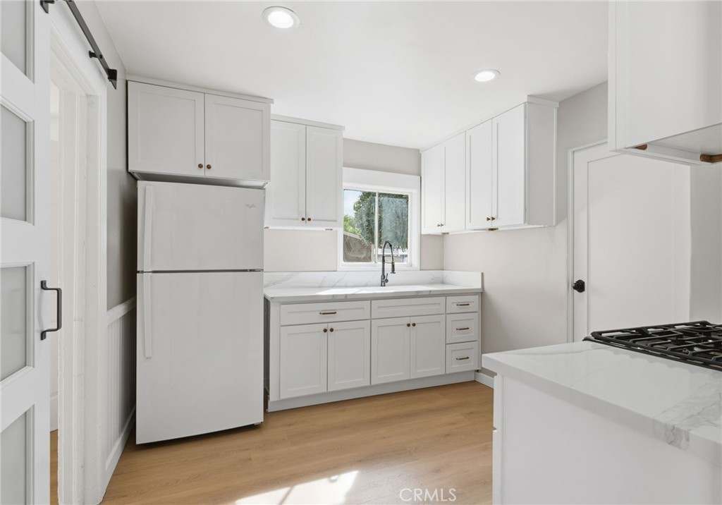3756 Locust Street Riverside, CA 92501 - Photo 11 of 22 a kitchen with white cabinets and refrigerator