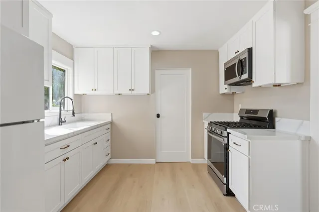 a kitchen with stainless steel appliances white cabinets and a sink