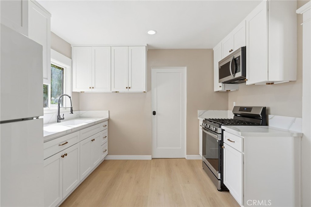 3756 Locust Street Riverside, CA 92501 - Photo 12 of 22 a kitchen with stainless steel appliances white cabinets and a sink