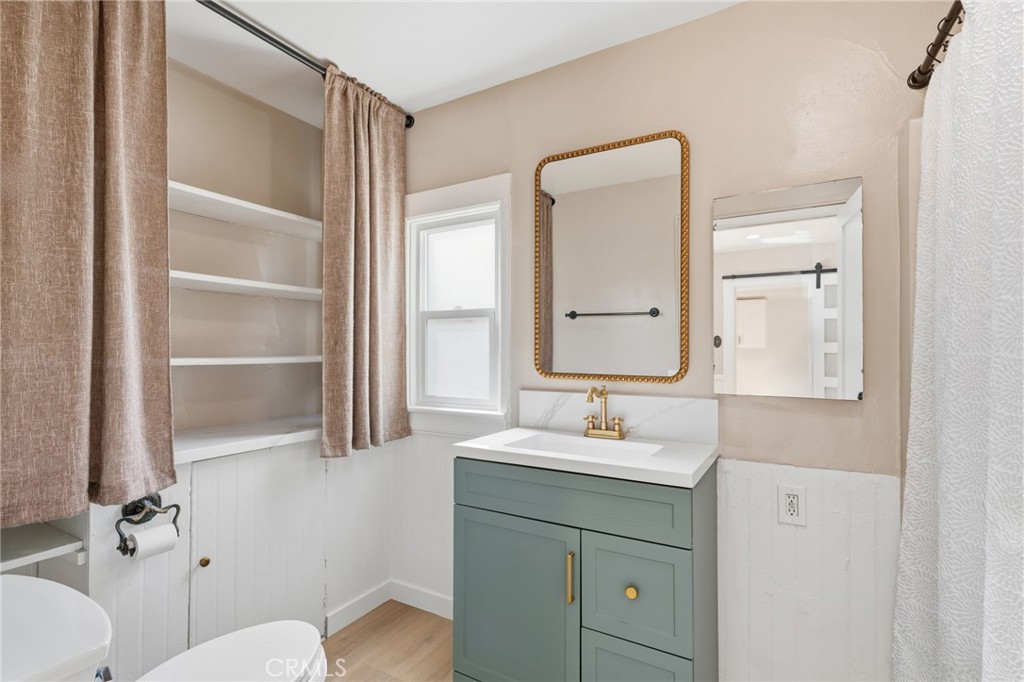 3756 Locust Street Riverside, CA 92501 - Photo 14 of 22 a bathroom with a sink a toilet a mirror and shower