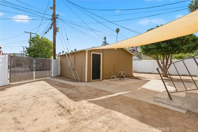 a view of a wooden house with a patio and a yard