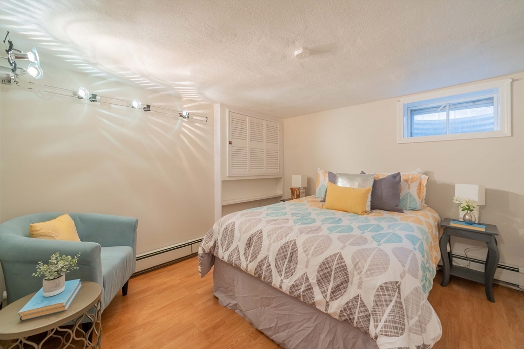 55 Sutherland Road, Unit 55 Arlington, MA 02476 - Photo 17 of 23 a bedroom with a bed and wooden floor