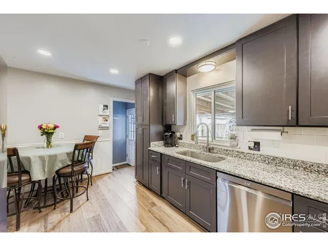 a open kitchen with granite countertop a sink and dishwasher with wooden floor