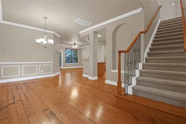 a view of a livingroom with wooden floor and stairs