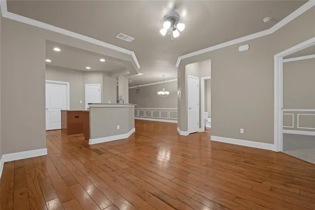 a view of a big room with wooden floor and a kitchen