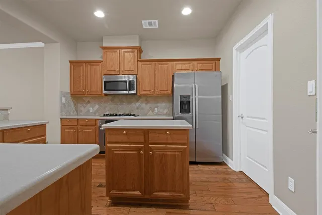 a kitchen with stainless steel appliances granite countertop a refrigerator and a stove
