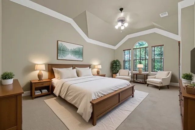 a spacious bedroom with a bed couch chandelier and windows